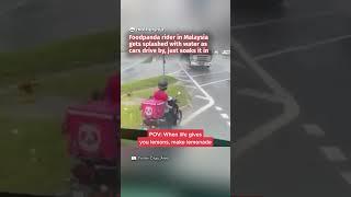 Foodpanda rider in Malaysia gets splashed by water as cars drive by, just soaks it in