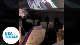 Plane passenger projects in-flight movie on overhead bin | USA TODAY